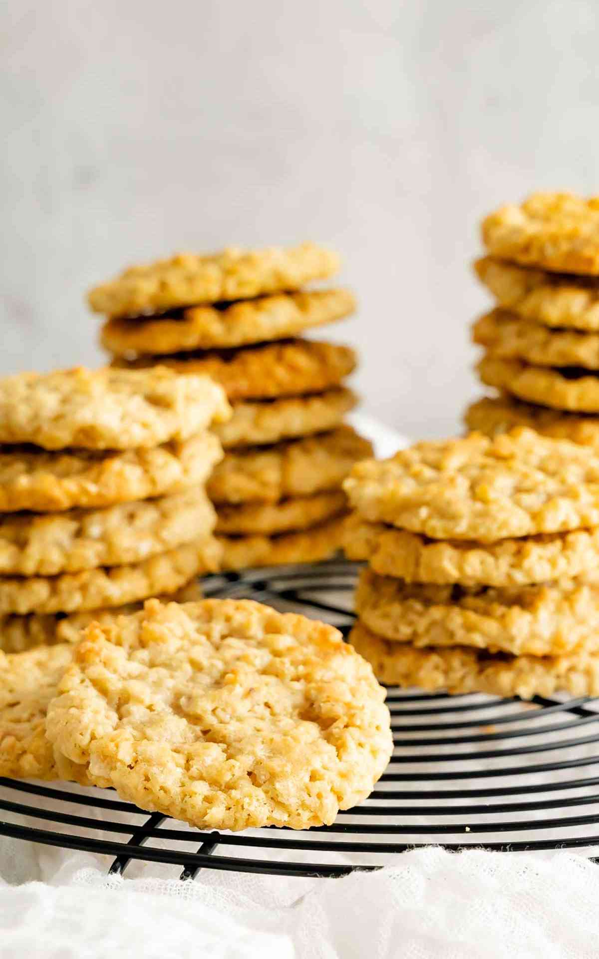 Classic old fashioned cracker jack cookies stacked on a black drying rack.
