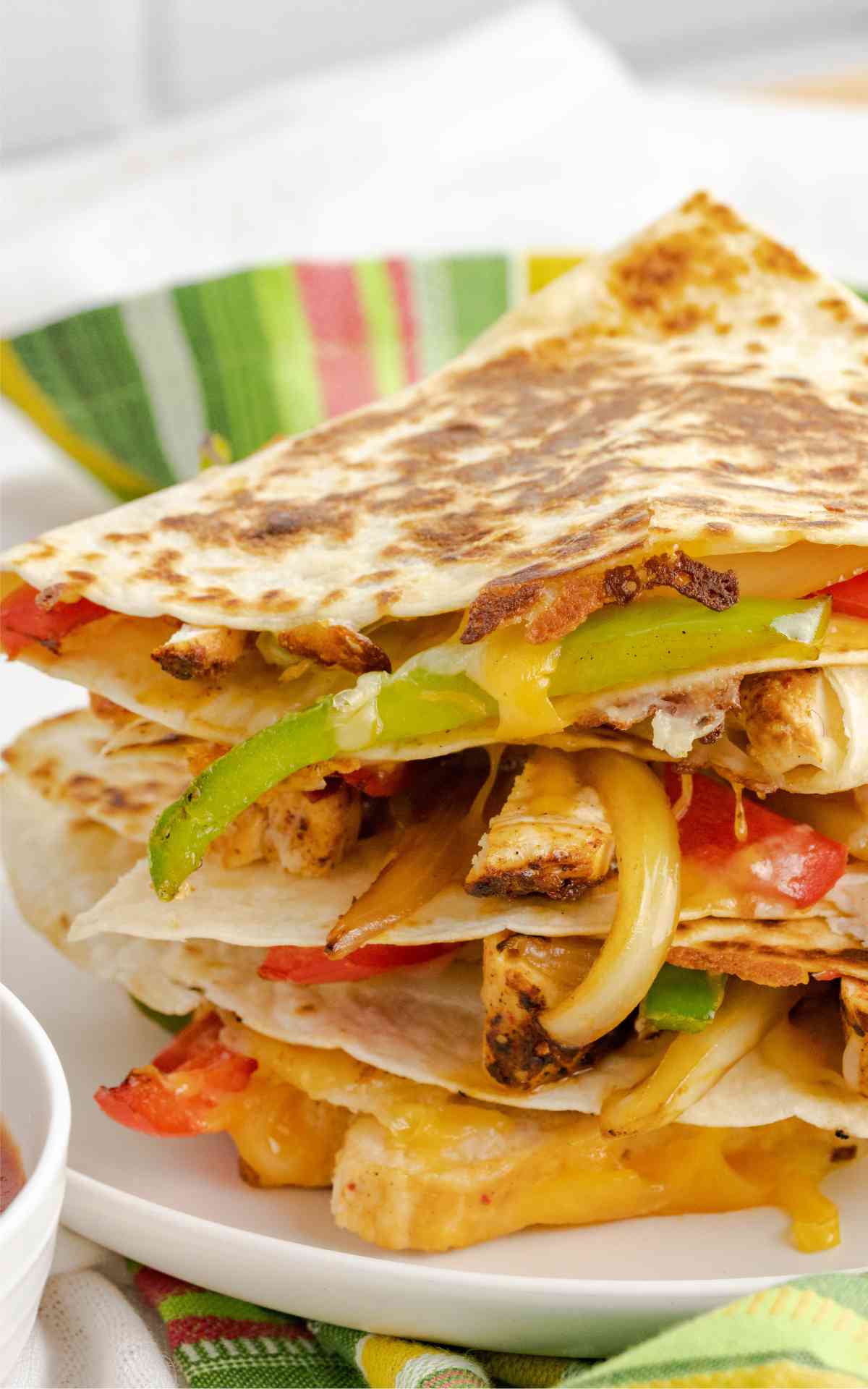 Close up of a stack of fajita chicken quesadillas that are golden brown