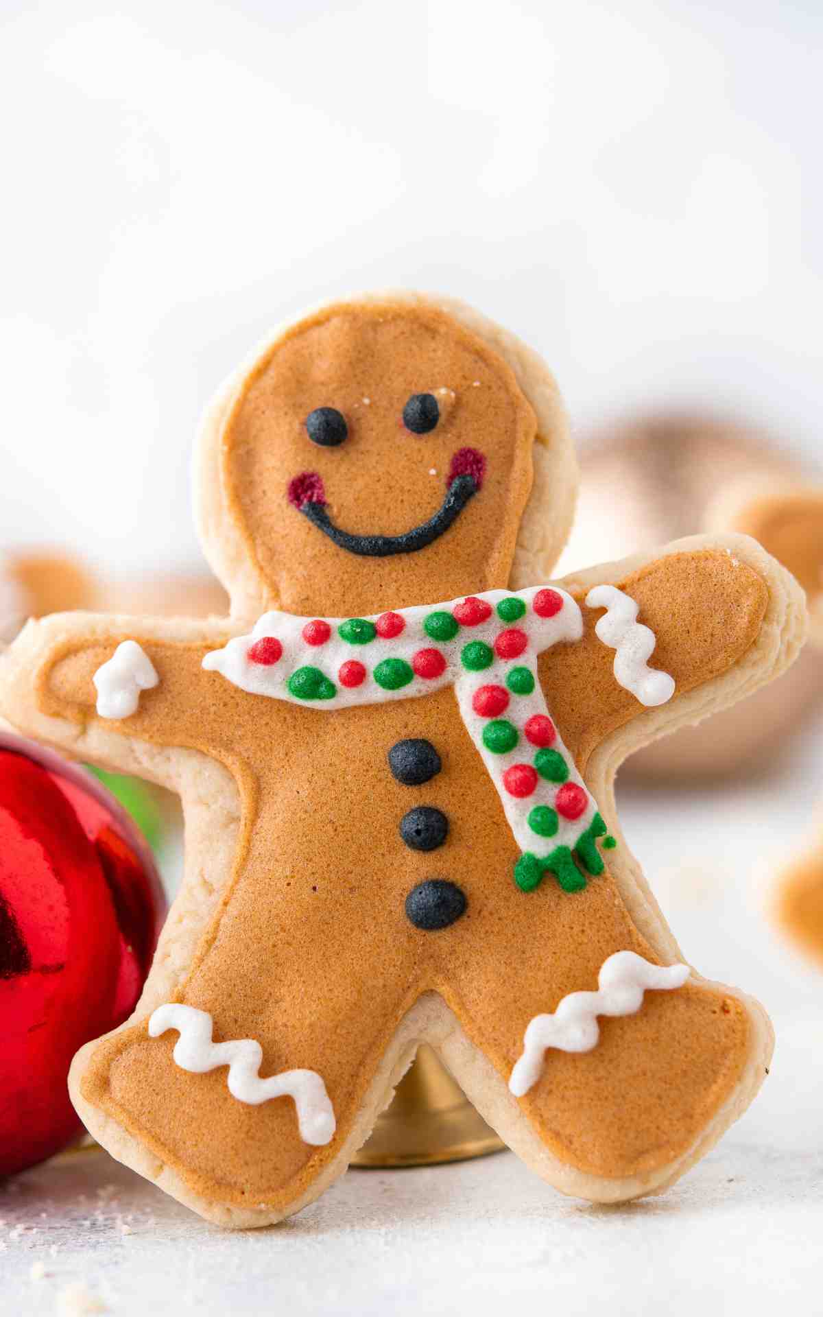One Gingerbread Man shaped Christmas sugar cookie decorated with scarf and buttons.