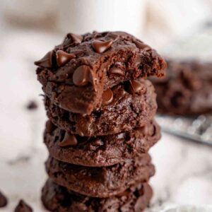 Stacked double chocolate fudge cookies with a bite taken.