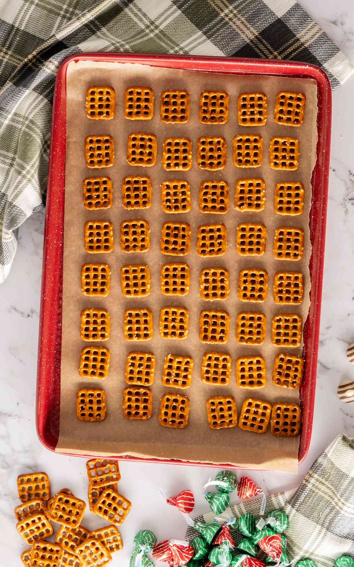 Pretzel snaps on a baking sheet lined with parchment paper.