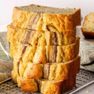 A stack of banana bread slices on a cooling rack.