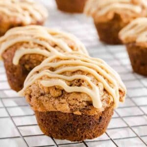 Close up of an unwrapped caramel banana muffin topped with caramel icing drizzle.
