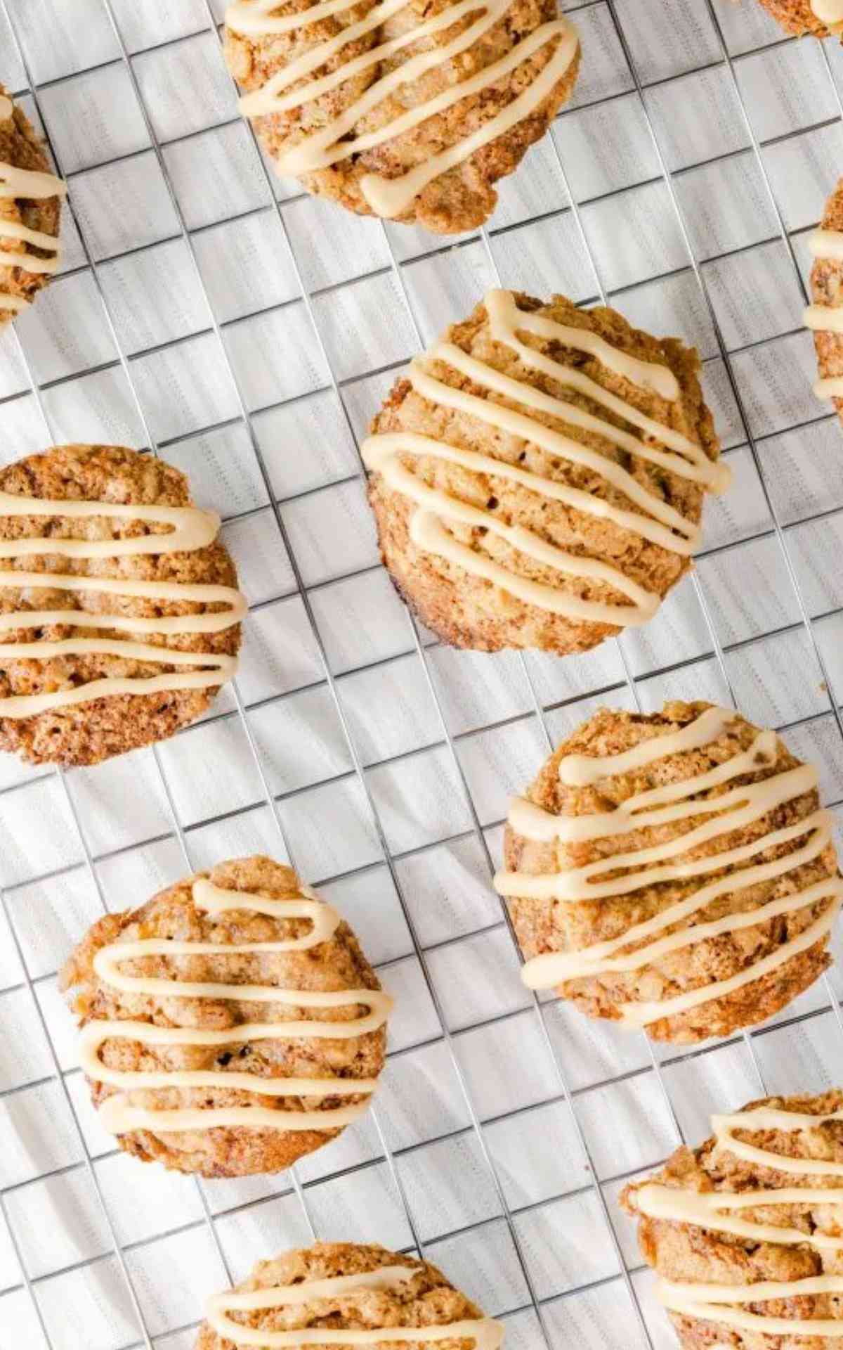 Banana caramel muffins spread out on a wire rack and drizzled with thick caramel icing.