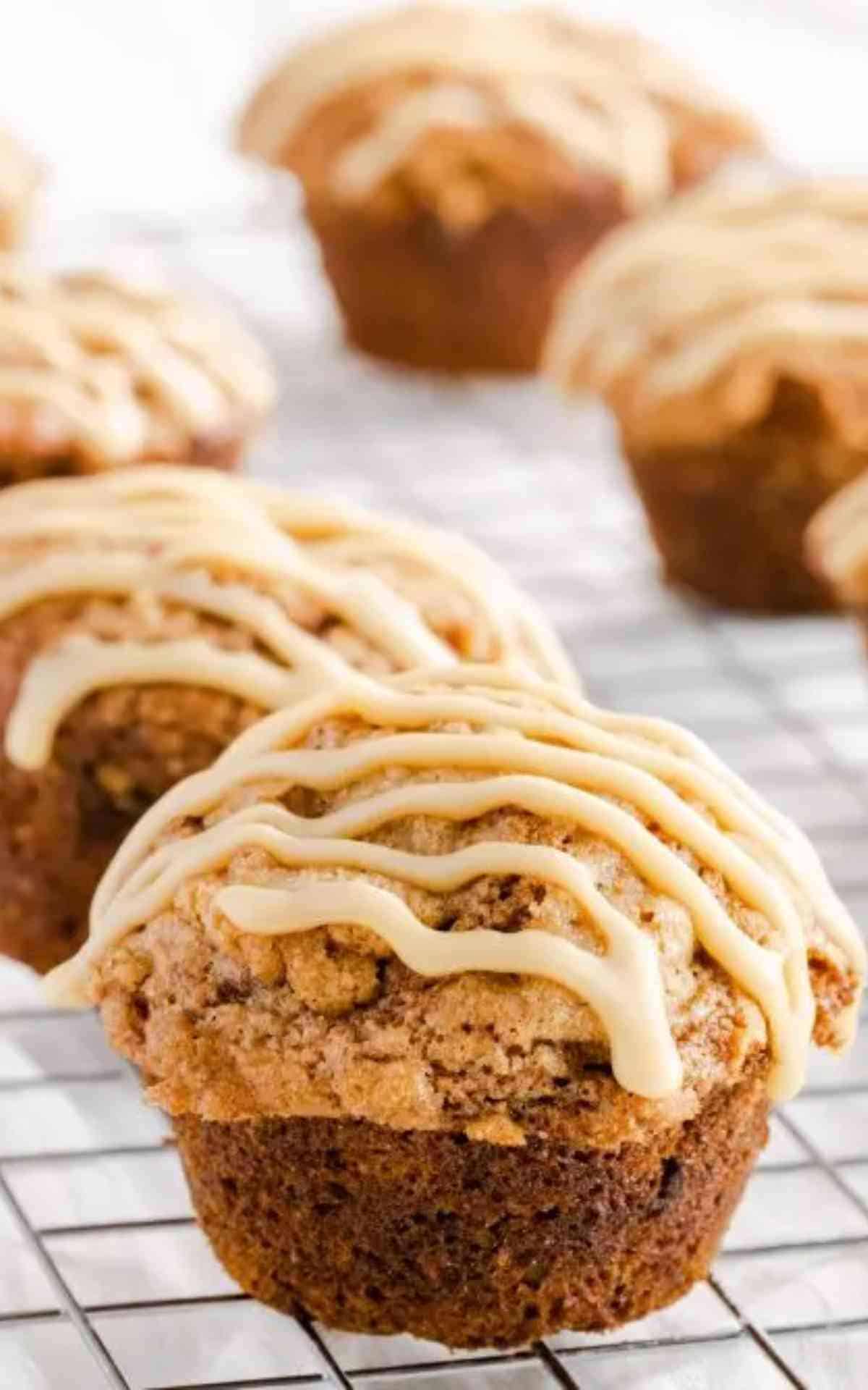 Close up of an unwrapped caramel banana muffin topped with caramel icing drizzle.