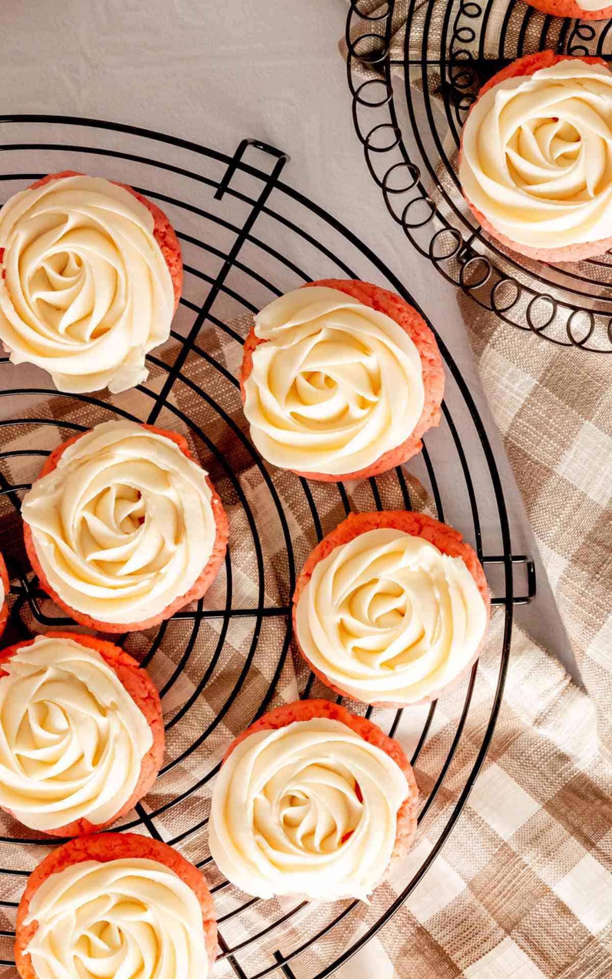 Close up of piped buttercream on pink lemonade flavored cookies.