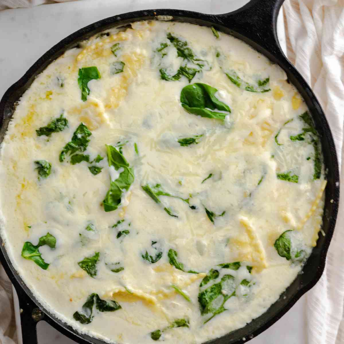 Birdseye view of a skillet of ricotta cheese spinach ravioli.