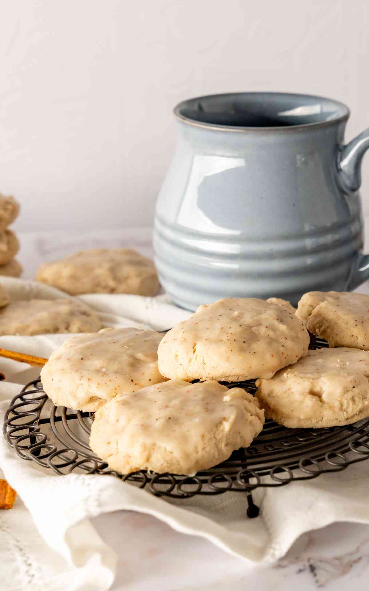 A few chai sugar cookies scattered on a cooling rack with a coffee mug in the background.