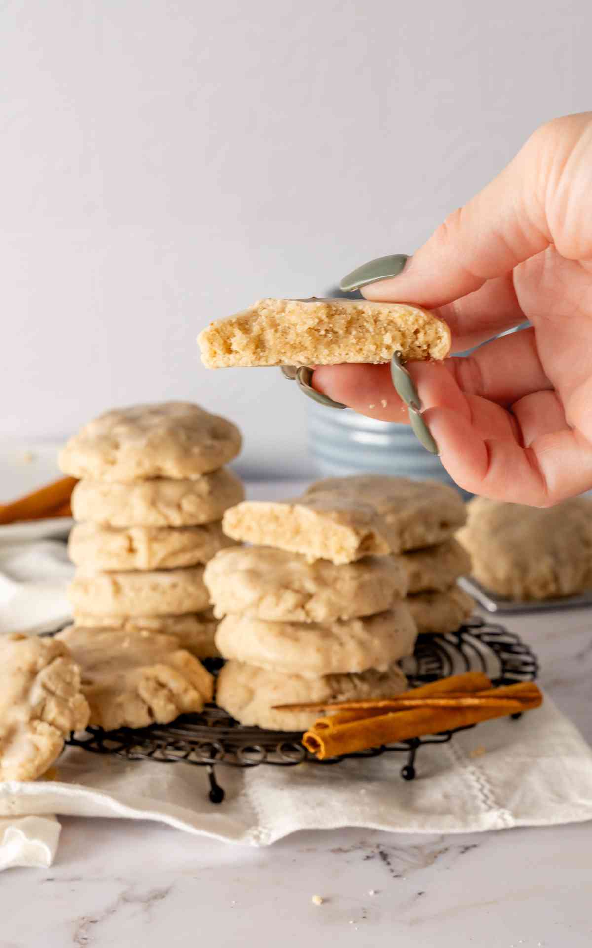 A manicured hand holding up a chai cookie cut in half.