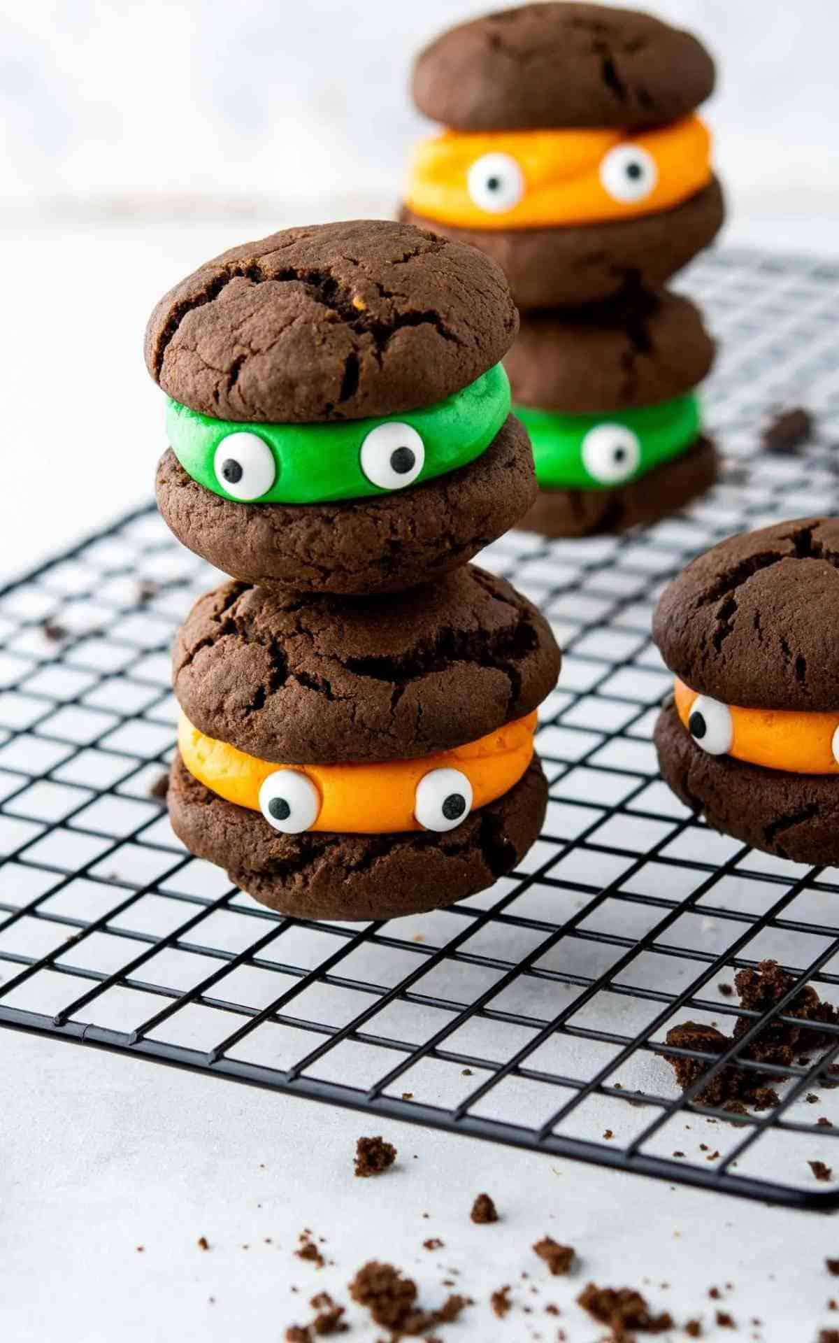 Stacked cream filled Halloween Monster Cookies with eyes.
