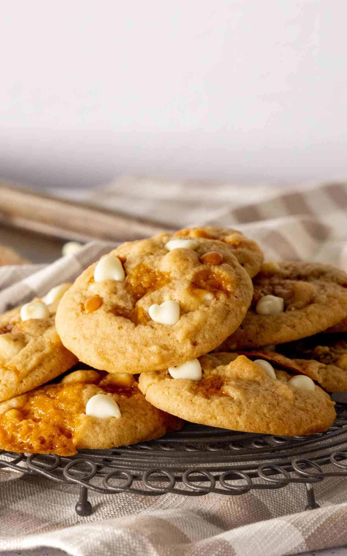 A stack of salted caramel cookies on a black cooling rack.