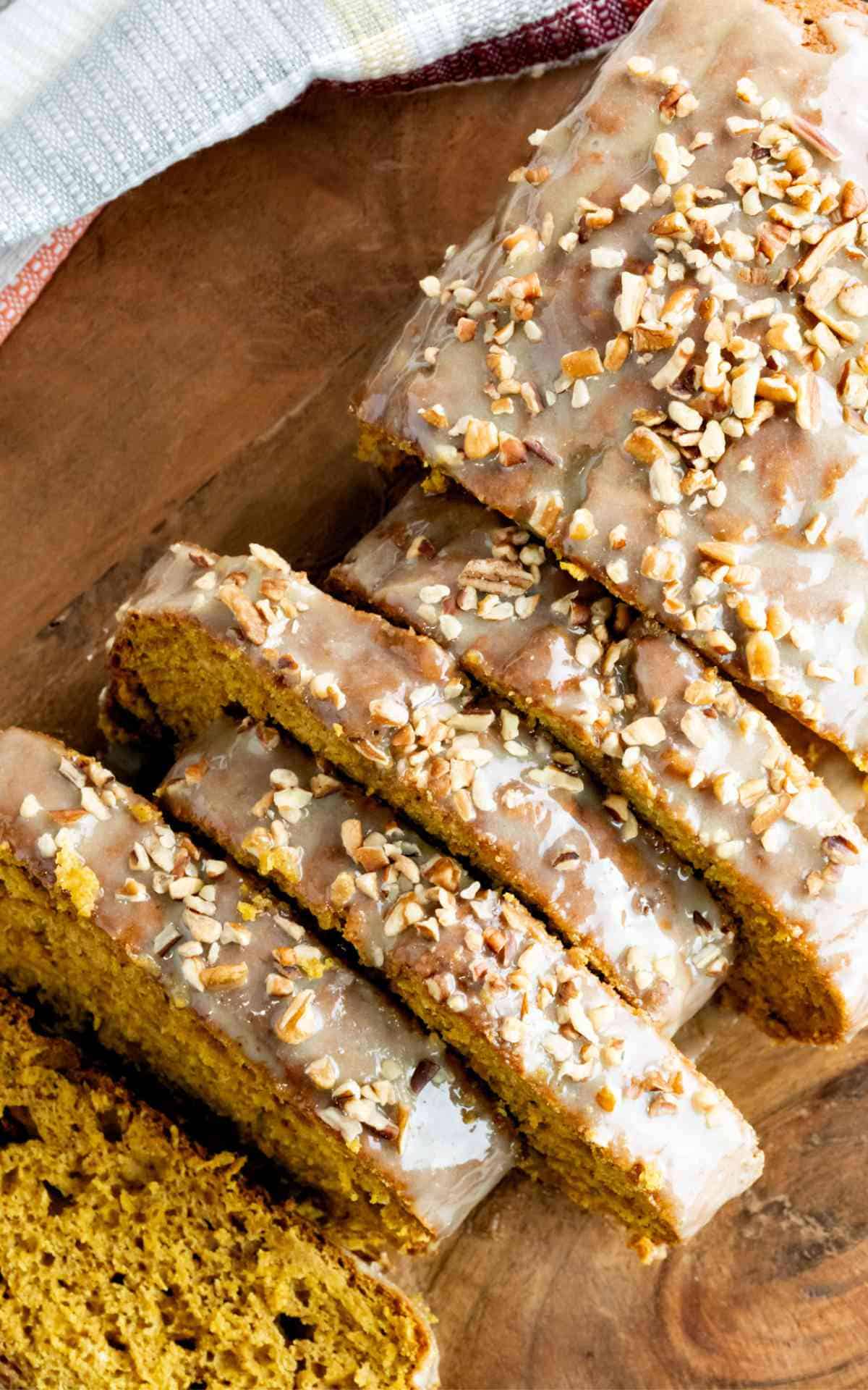 Iced pumpkin loaf with caramel icing and chopped pecans.