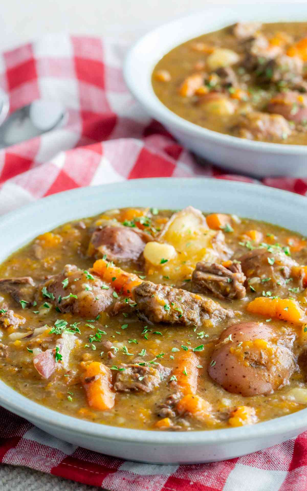 Two bowls of Instant Pot Beef Stew in blue stoneware bowls.
