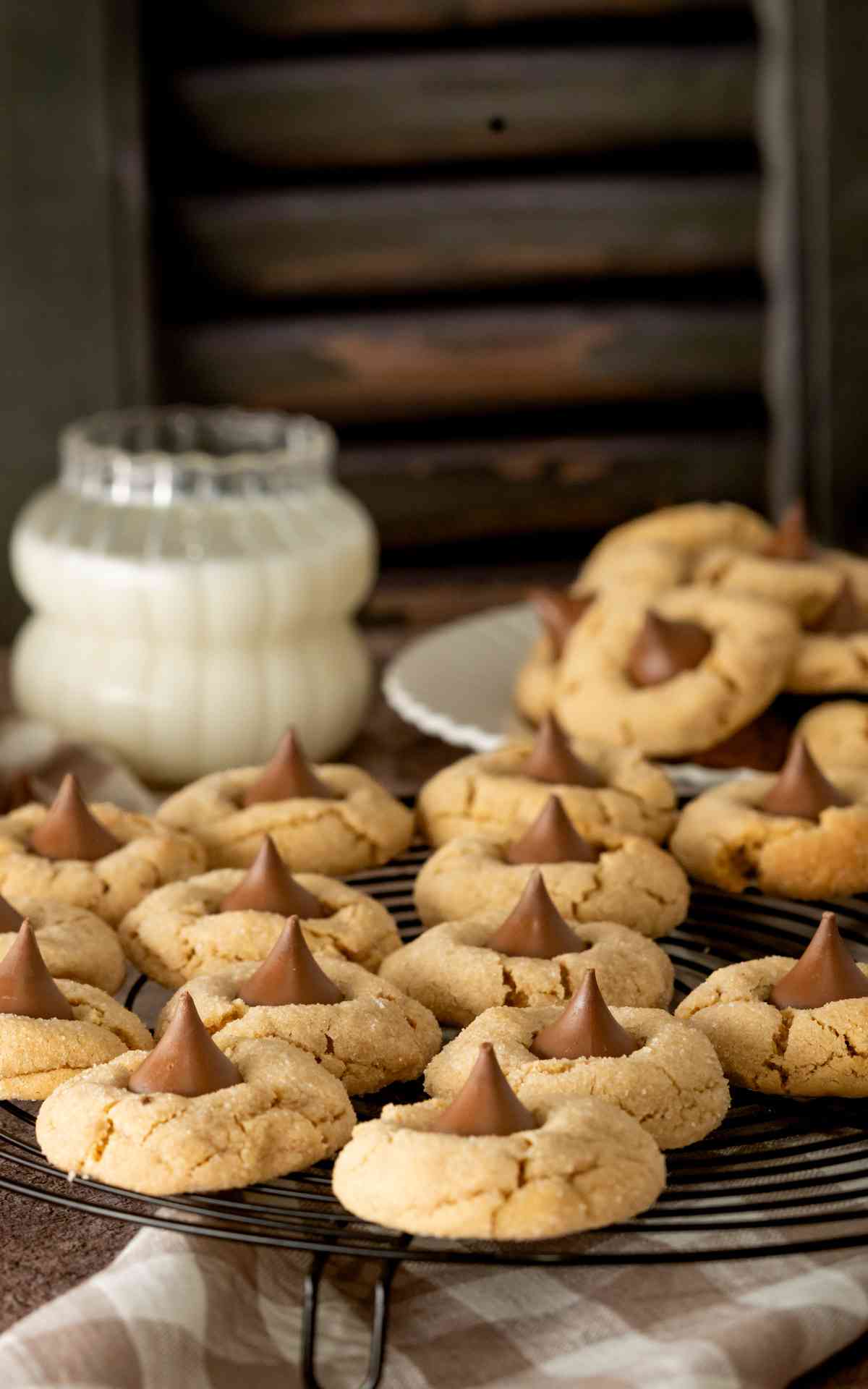 A black rack with peanut butter blossom cookies cooling on it.