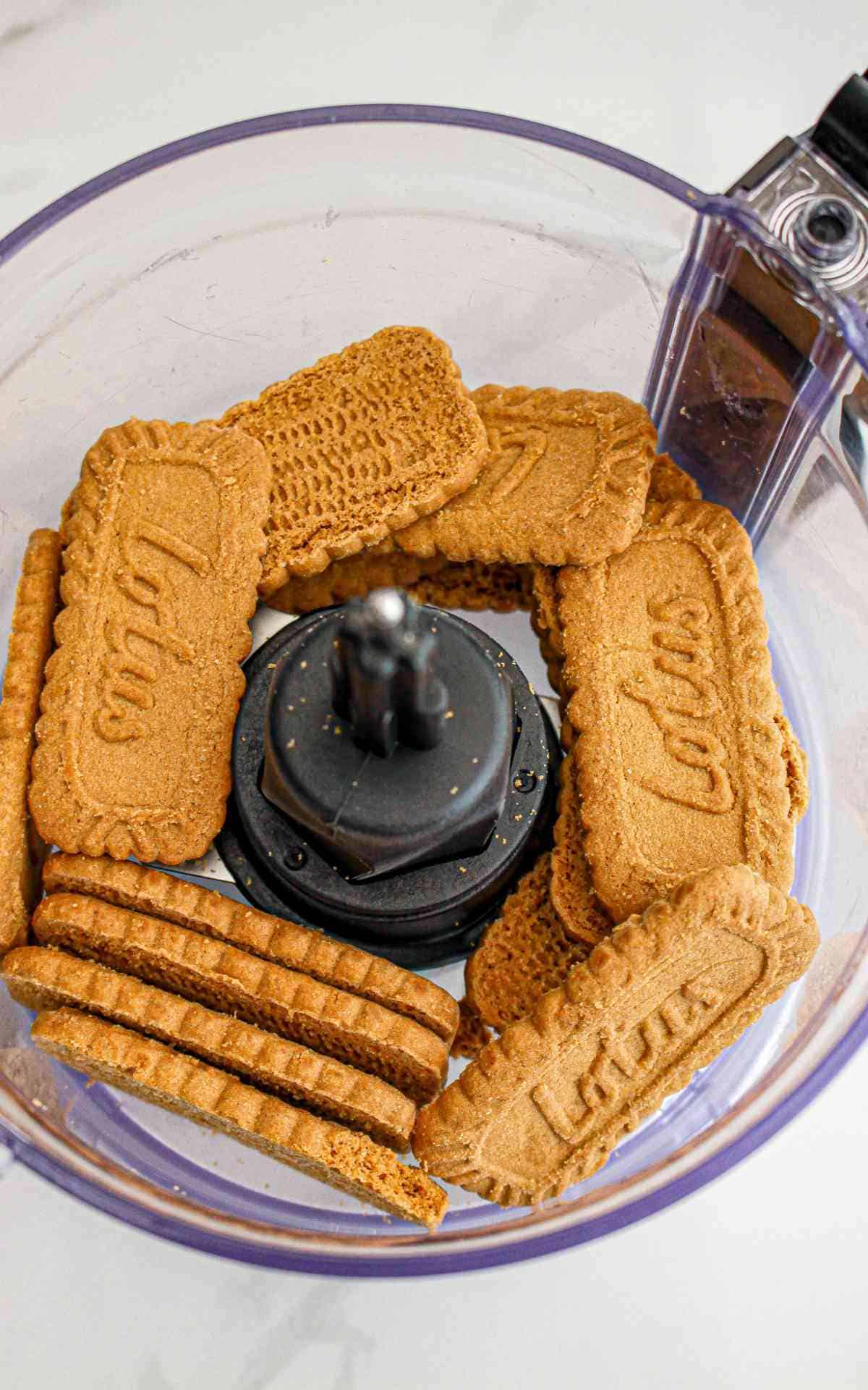 A food processor with whole Lotus Biscoff cookies.