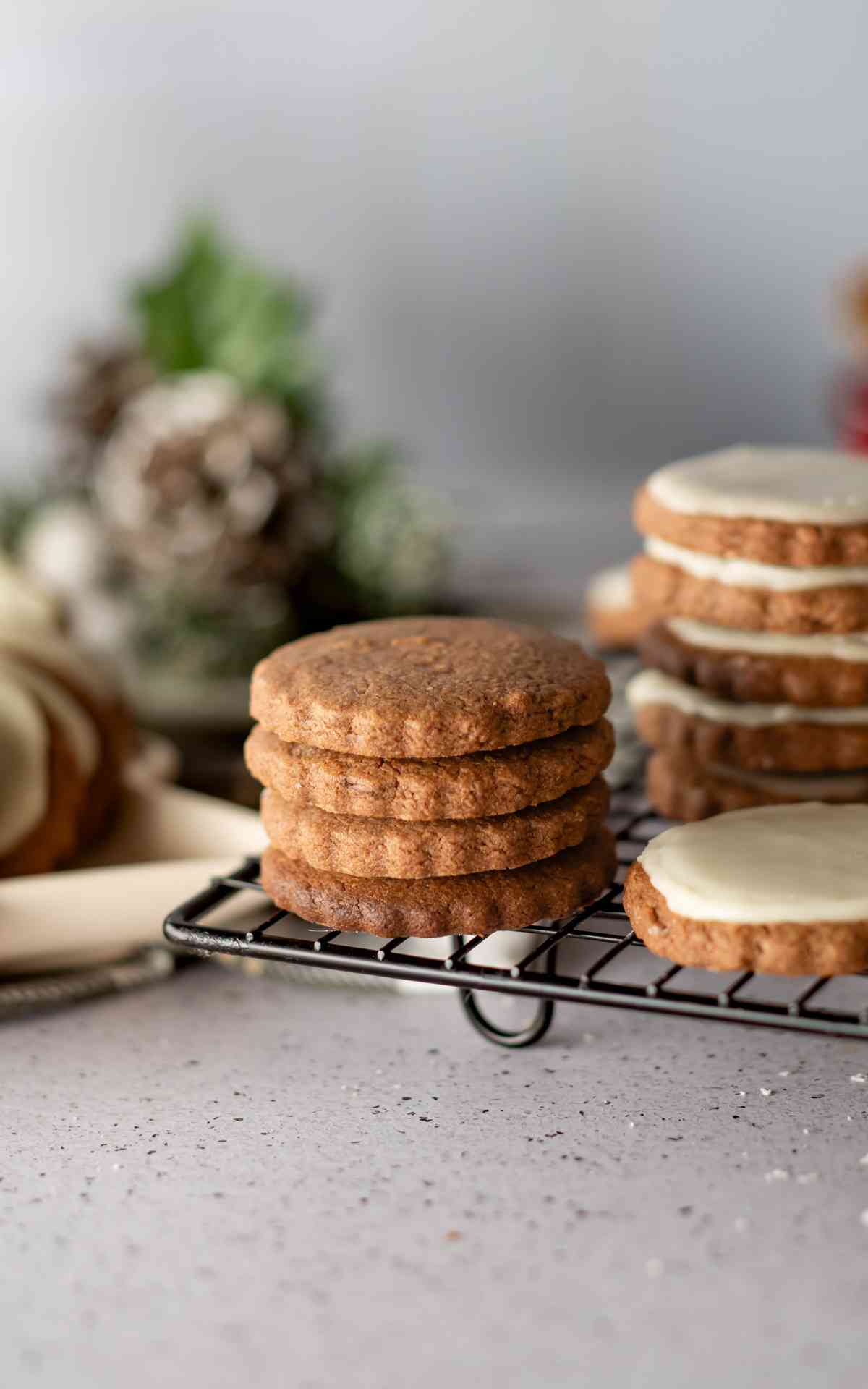 Four chocolate orange cookies stacked and unfrosted next to glazed cookies.