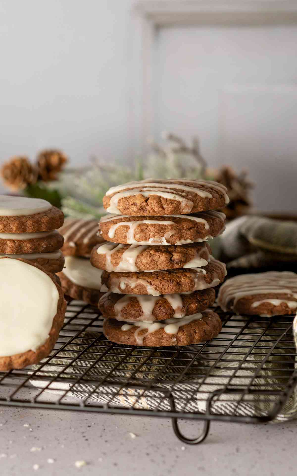 Six drizzled cookies stacked on a wire rack.