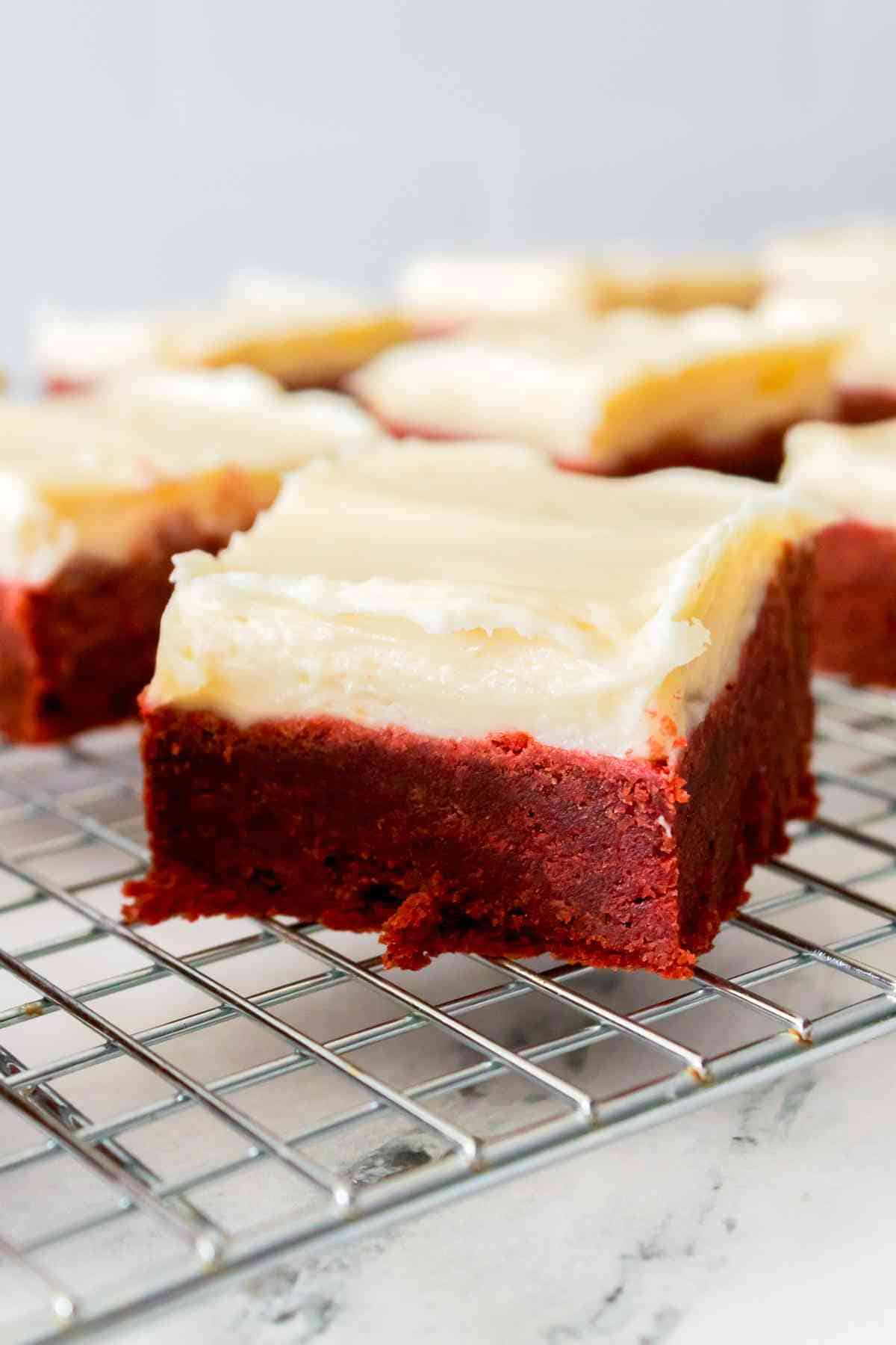 Red velvet cookie bars topped with homemade cream cheese frosting.
