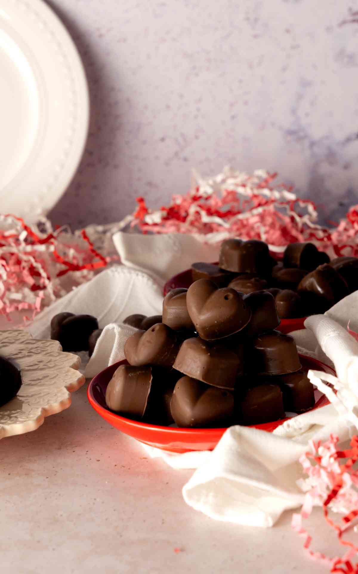 Valentines heart shaped chocolate candies on a red plate.