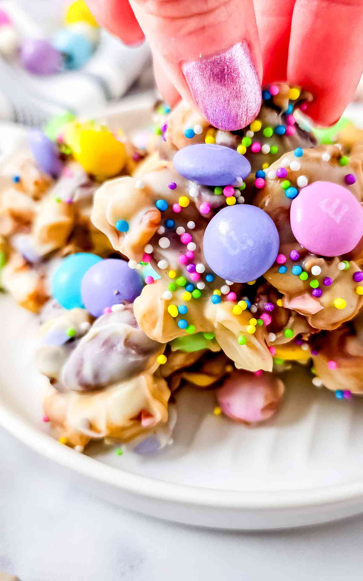 A hand picking up a piece of Crockpot Easter candy.