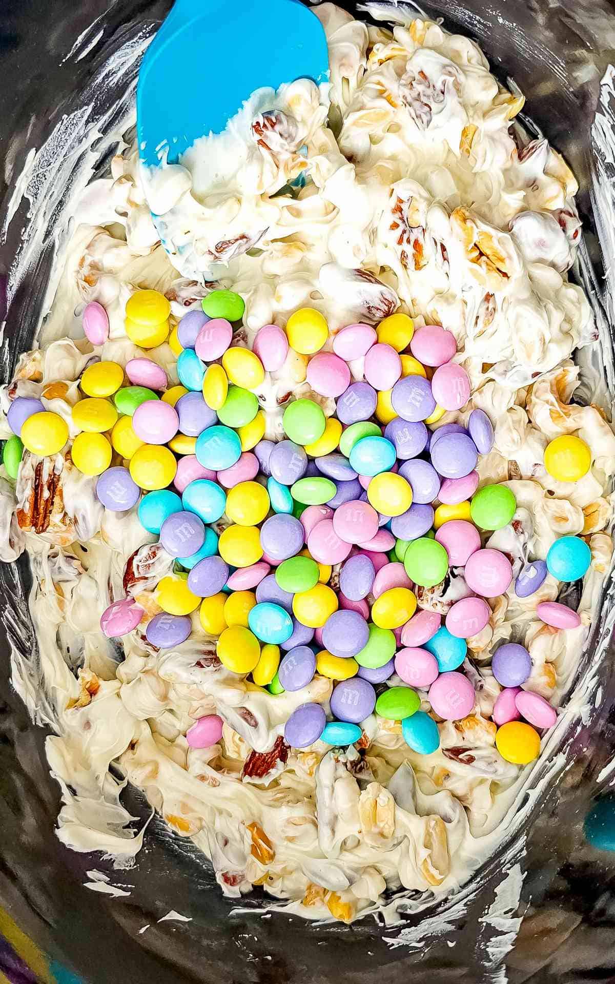 Crockpot Easter Candy being stirred in the slow cooker.