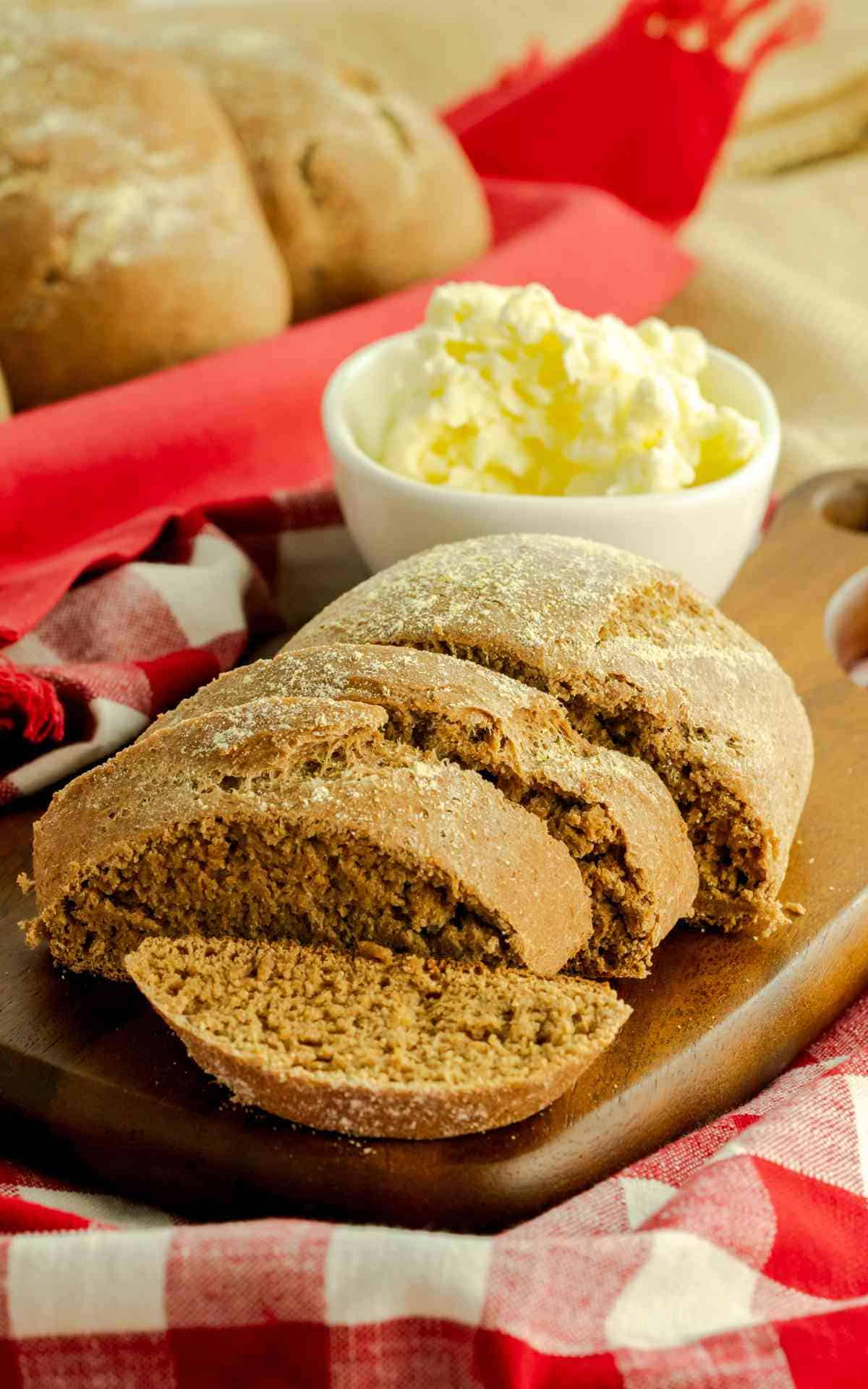 Sliced honey wheat bread on a serving board.