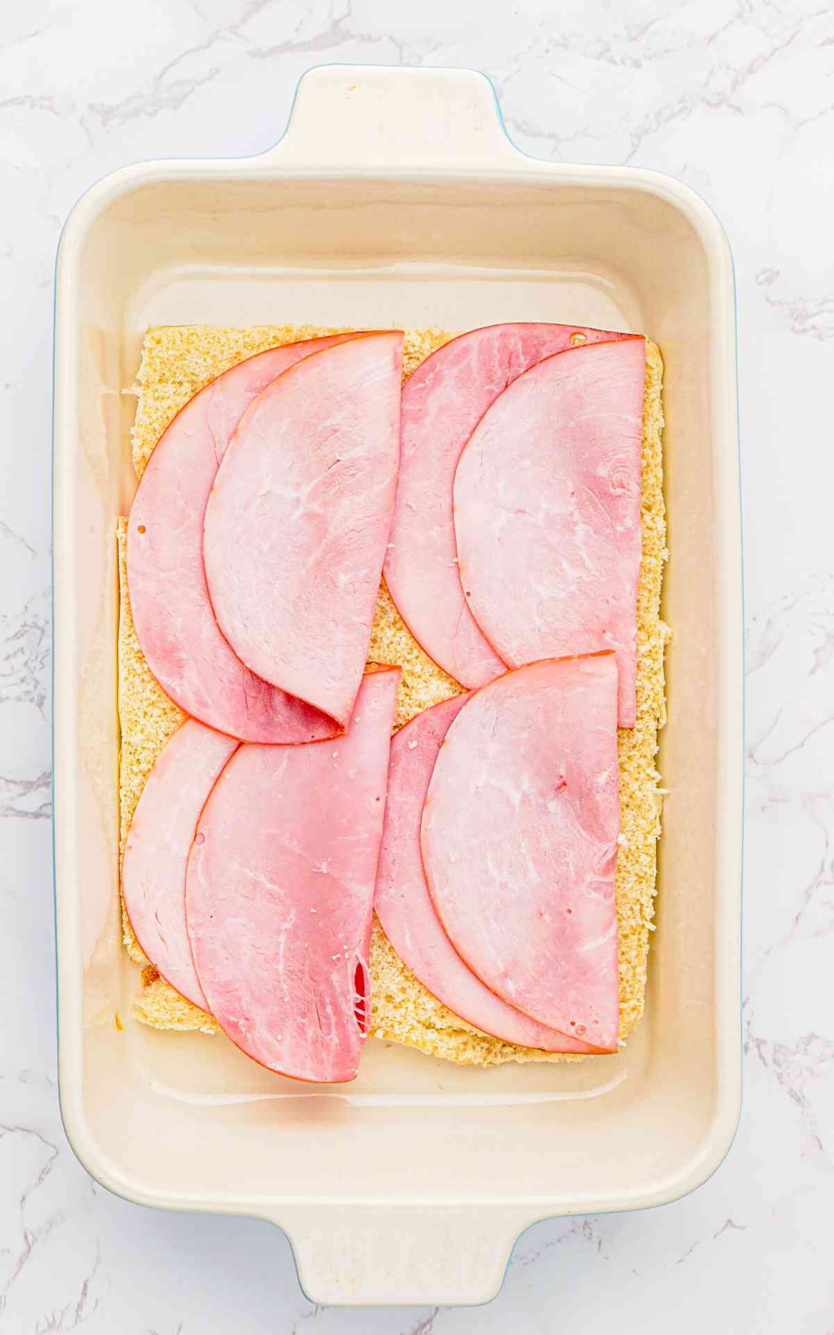 Process for making ham and cheese sliders without the tops of the buns.