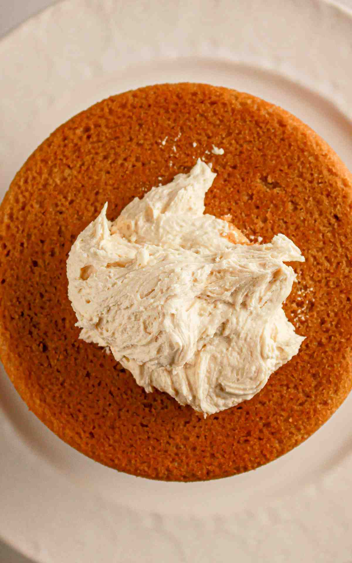 Espresso buttercream on top of a cake layer before being spread.