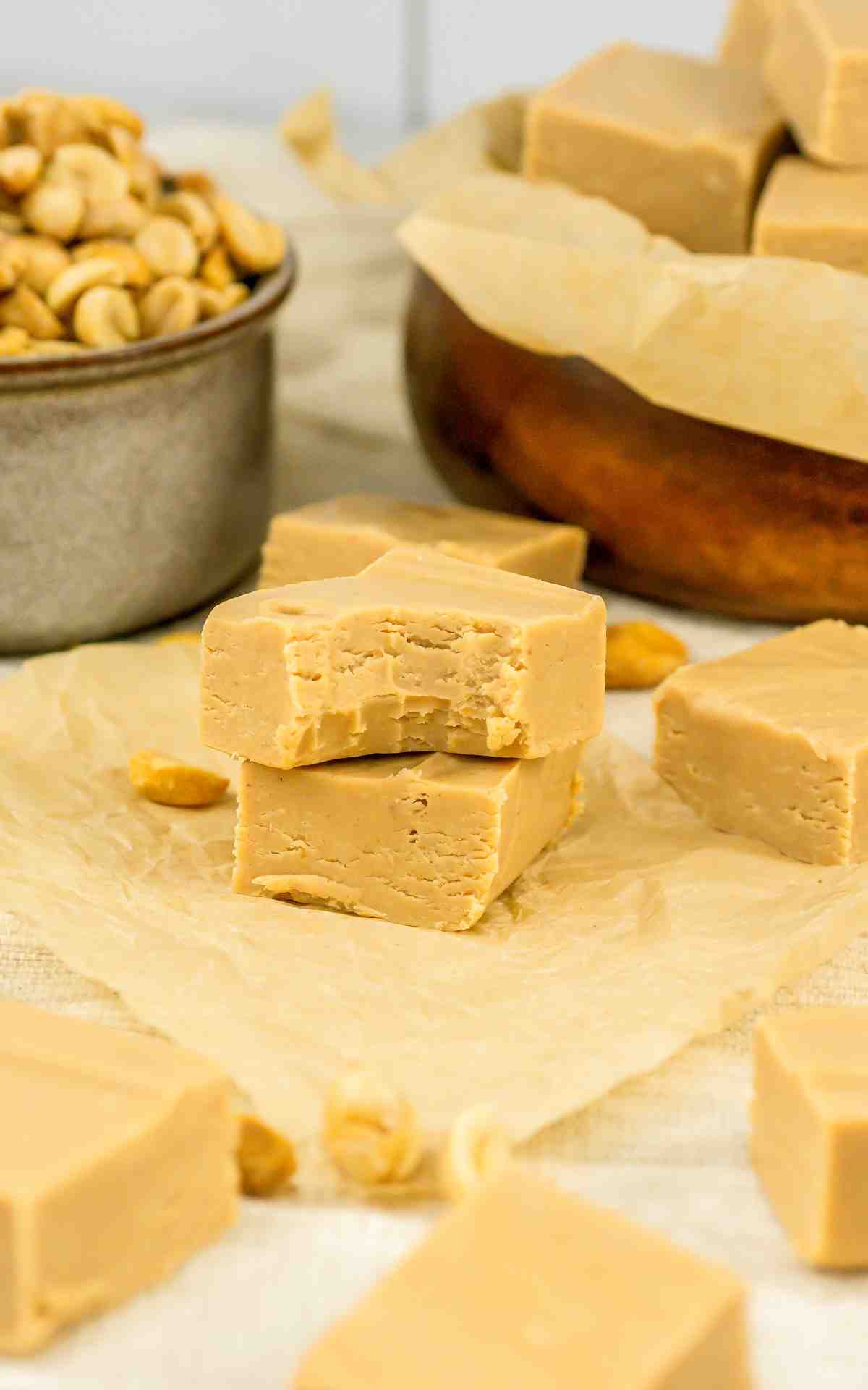 Two pieces of 2 ingredient peanut butter fudge on parchment.