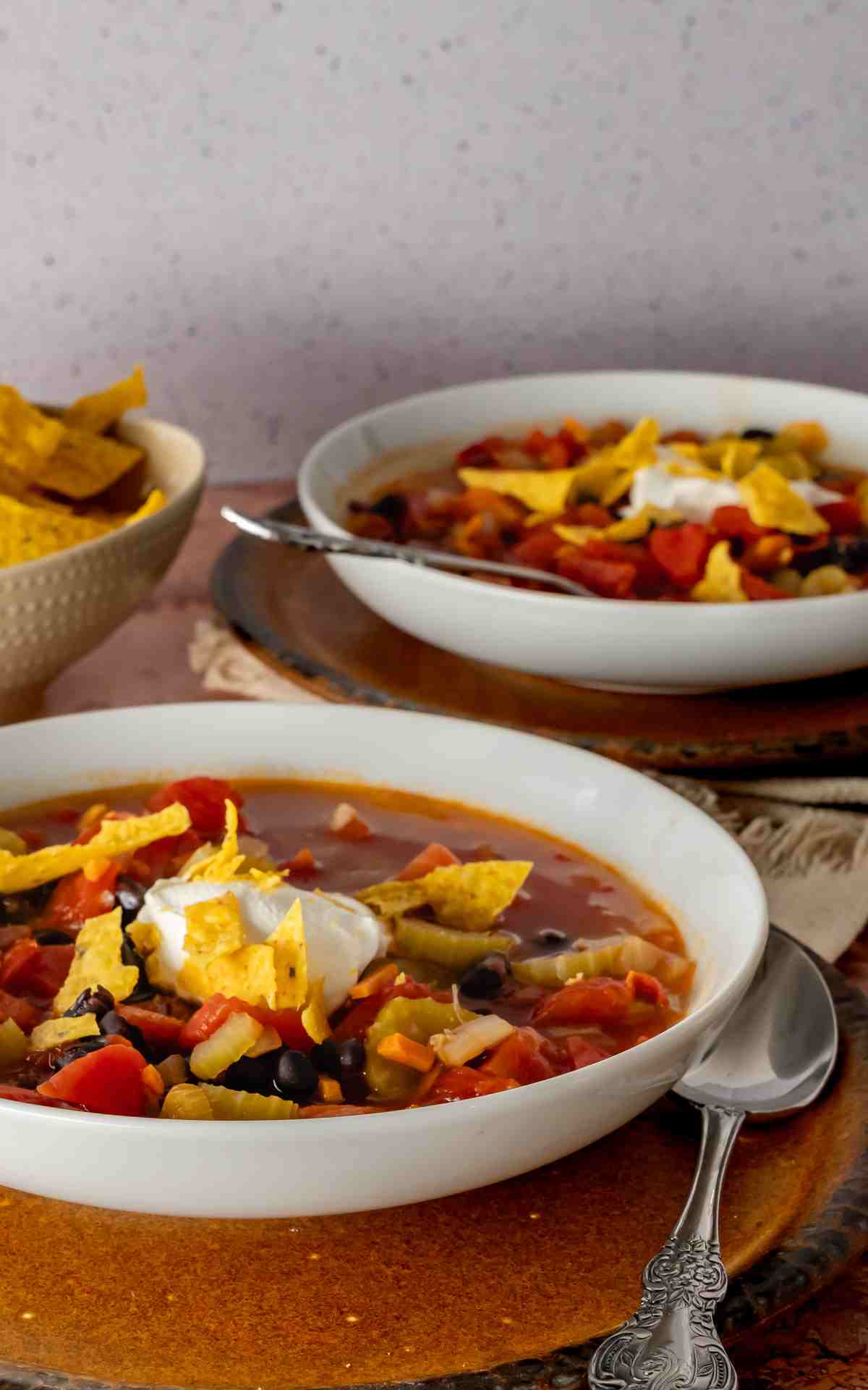 Two bowls of Mexican style black bean soup on the counter.