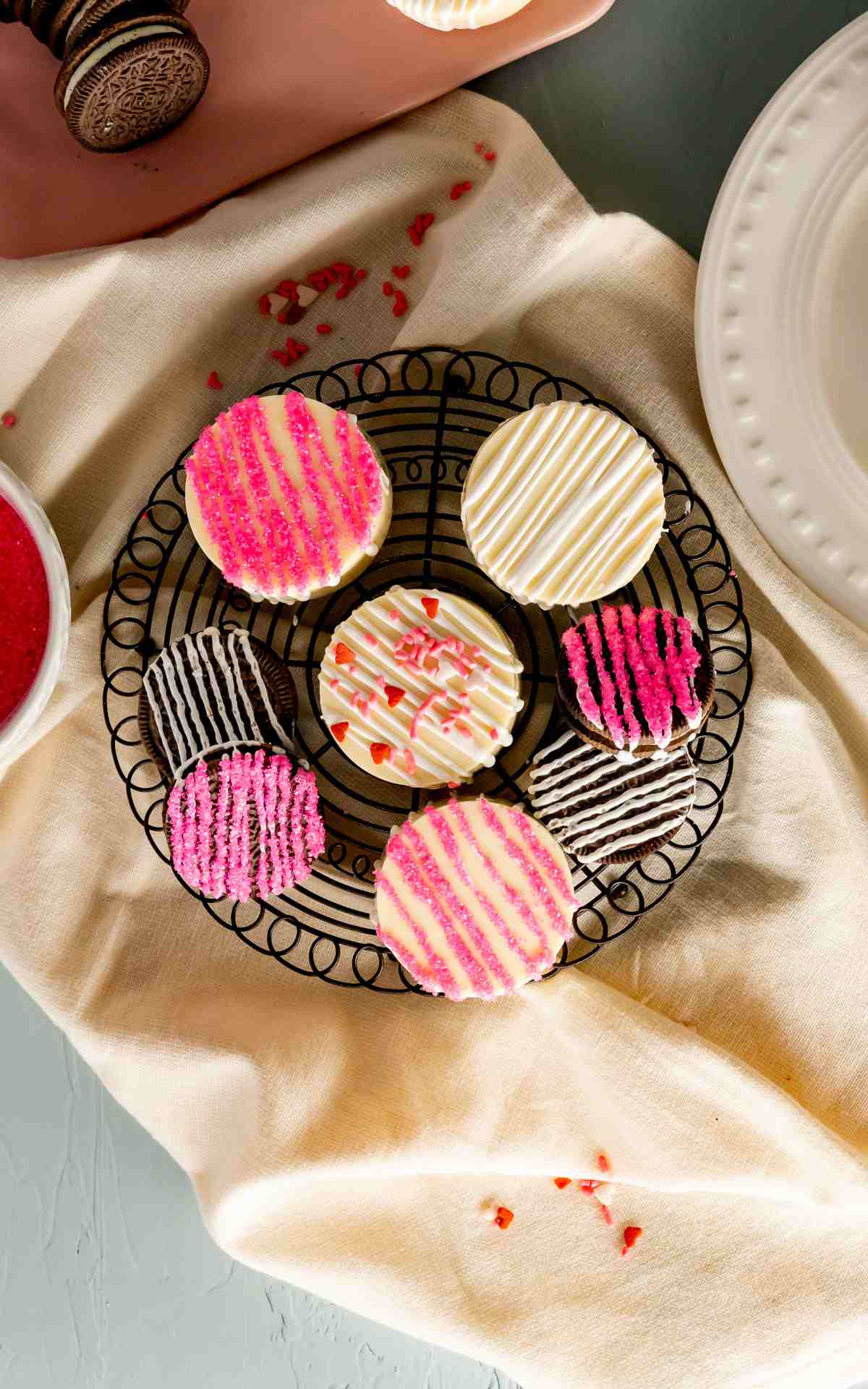 Valentine's Day decorated chocolate covered Oreos. on a wire rack.