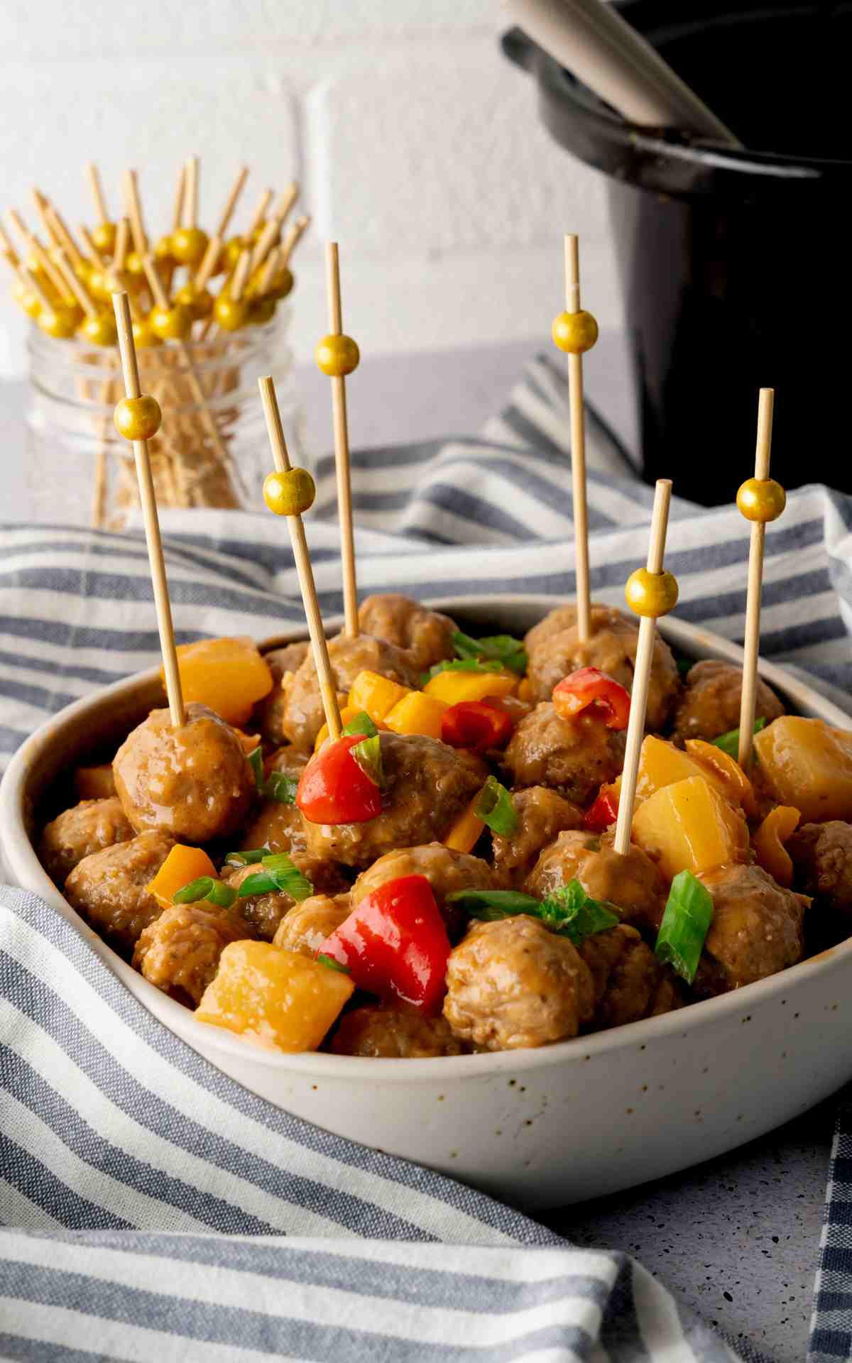 Cocktails picks stuck in crockpot sweet and sour meatballs.