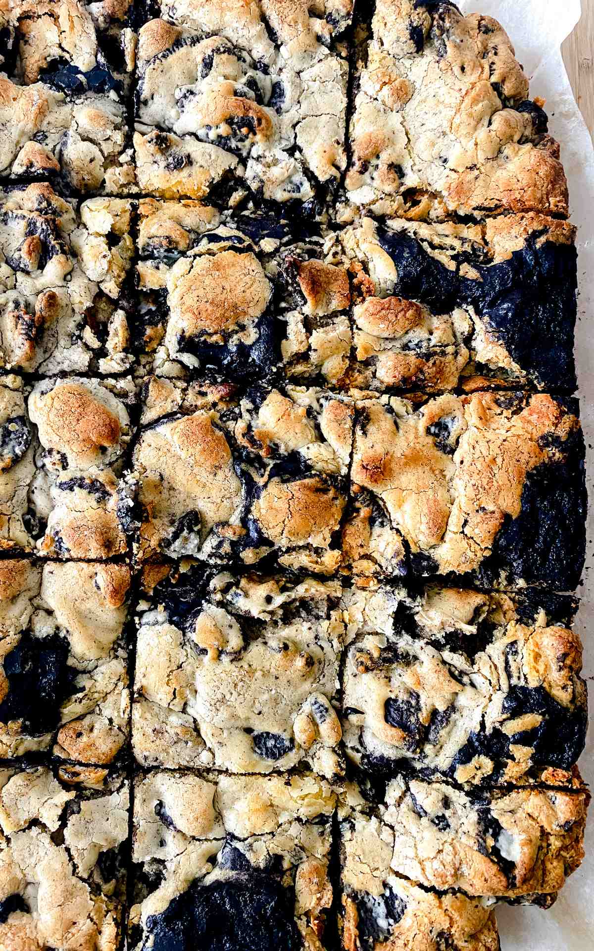 Oreo brownie bars cut on parchment paper.