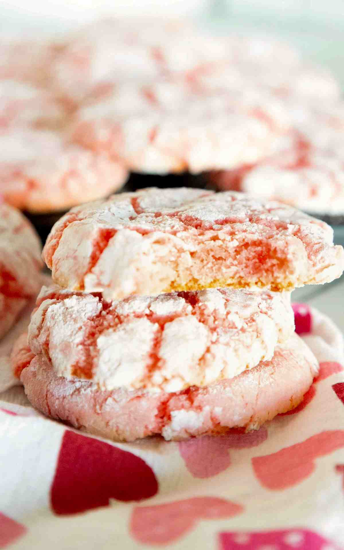 Stacked cake mix cookies that are strawberry flavored and rolled in powdered sugar.
