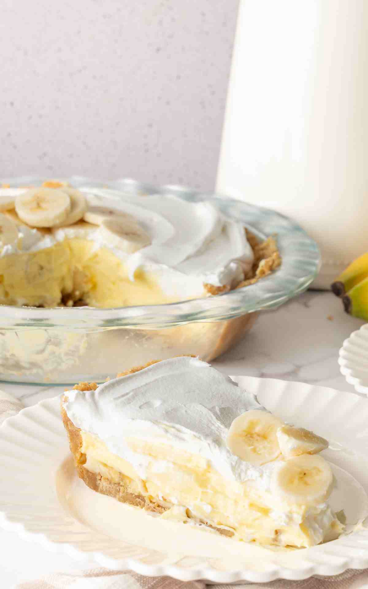 A slice of banana cream pie with pudding on a plate.