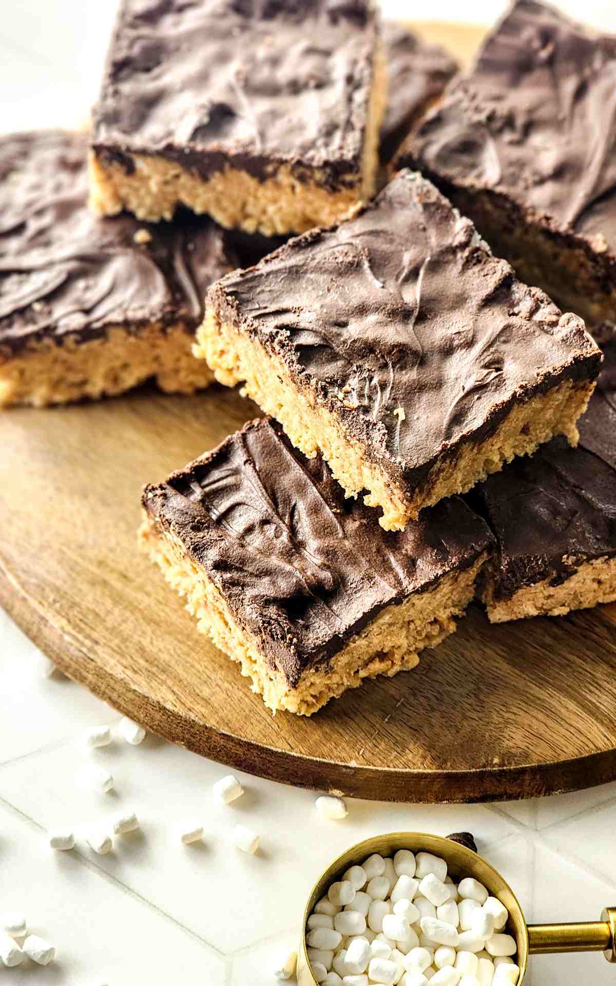 A stack of peanut butter and rice krispies bars on a wooden board.