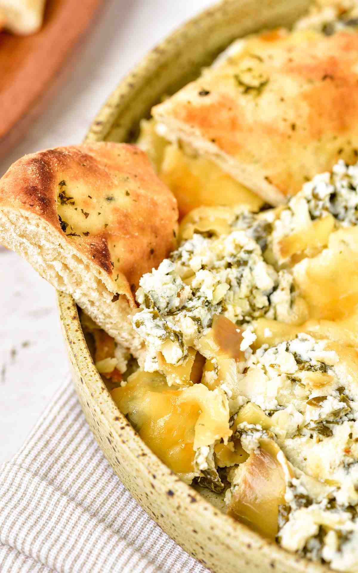 Spinach art.ichoke dip with dippers in the bowl