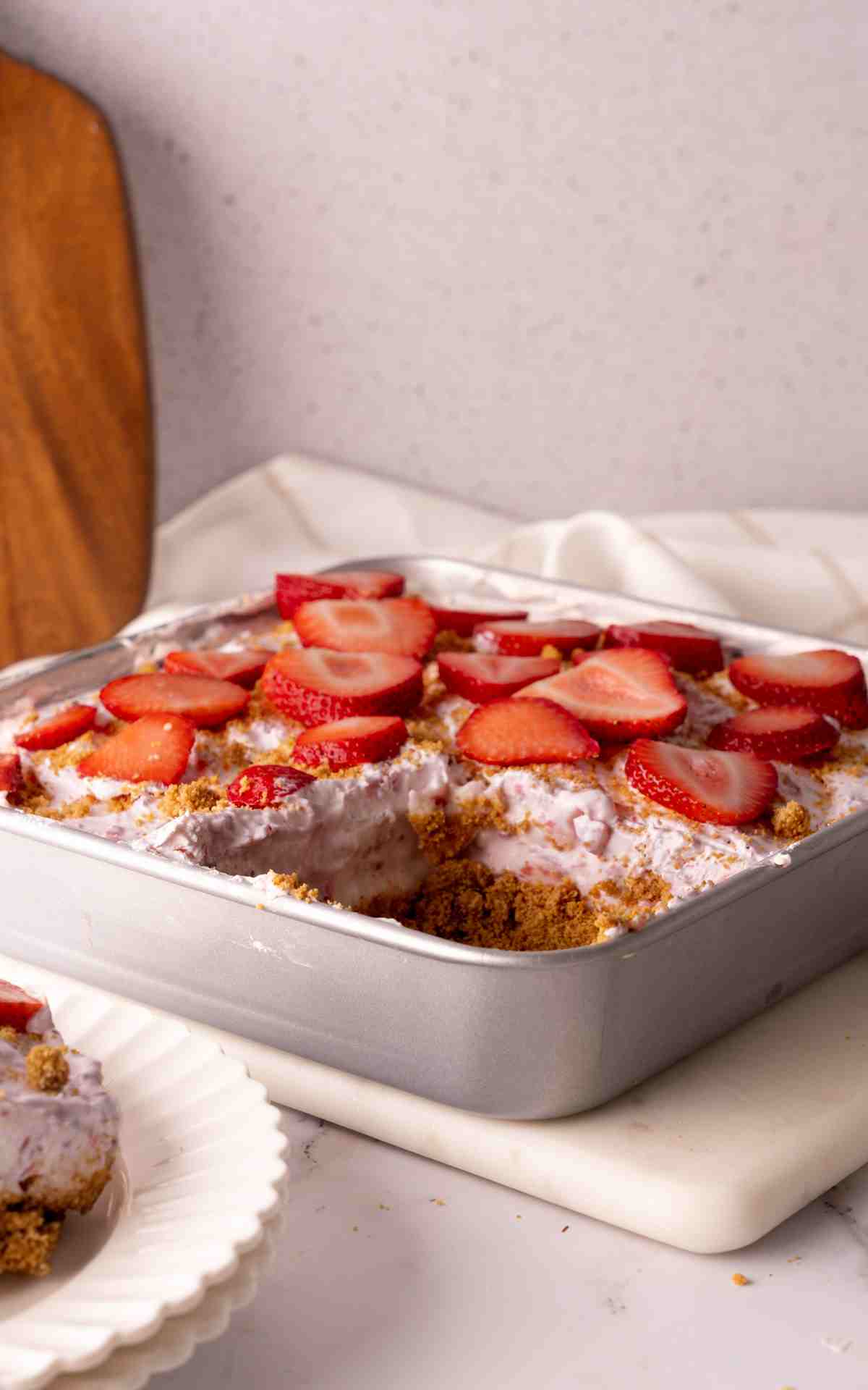 A slice taken out of a strawberry delight in a baking pan.