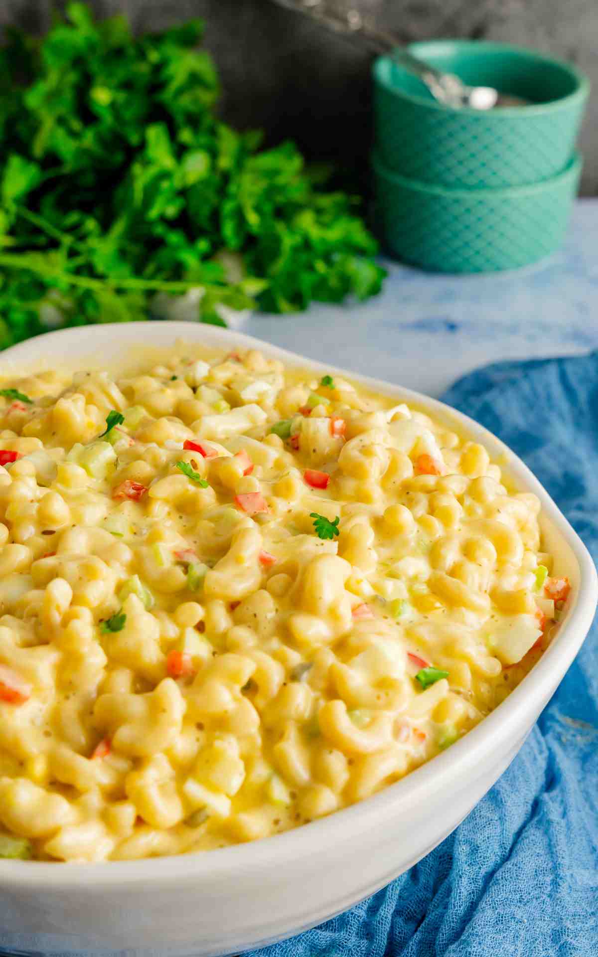 Creamy macaroni salad in a large bowl on a blue countertop.