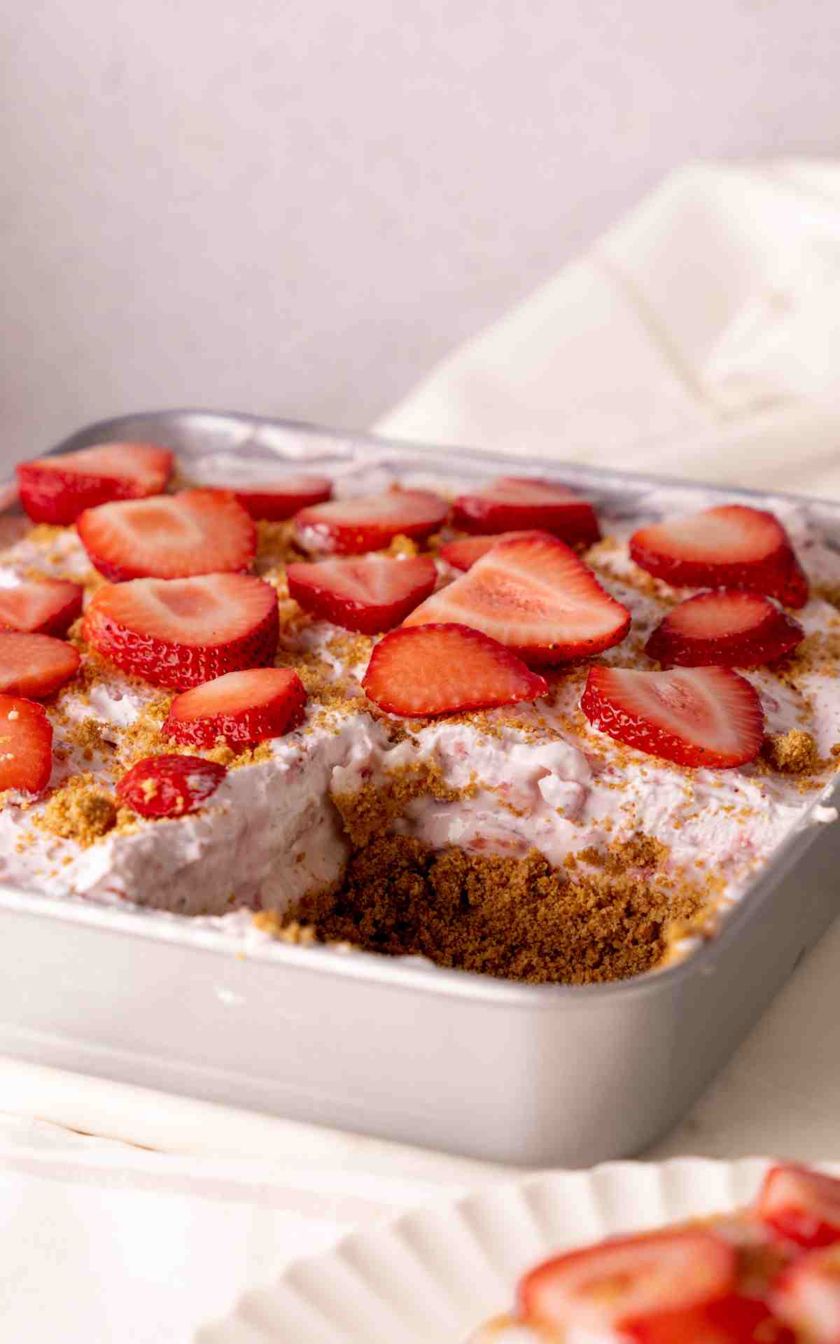 Icebox strawberry dessert in a square baking dish.