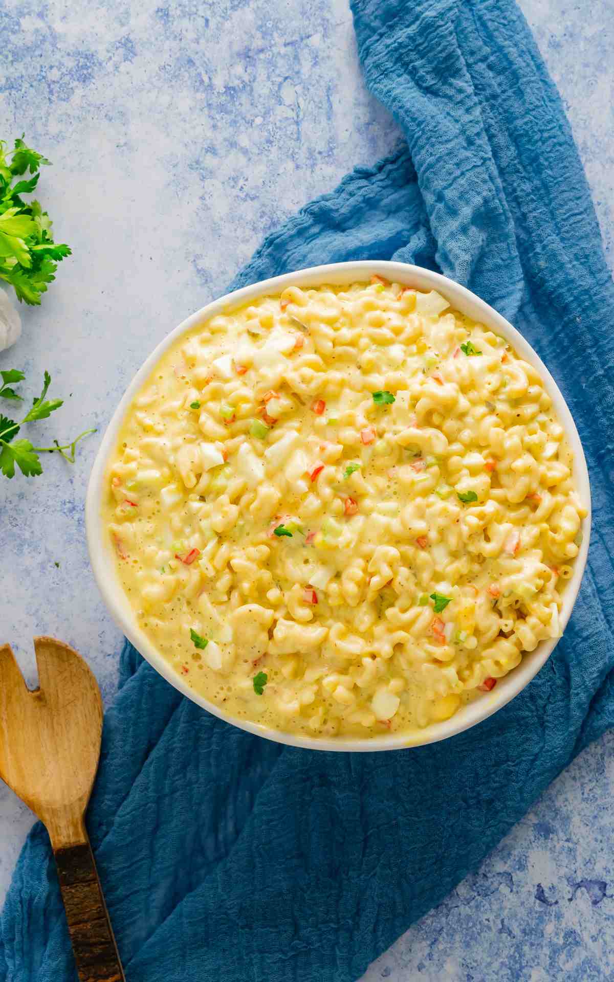 Top view of an Amish macaroni salad recipe with blue linens.