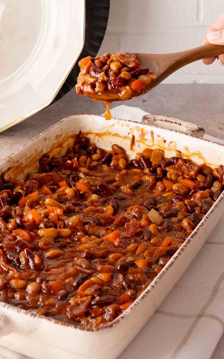 A spoonful of bbq beans beans that are oven baked beans hot out of the oven.