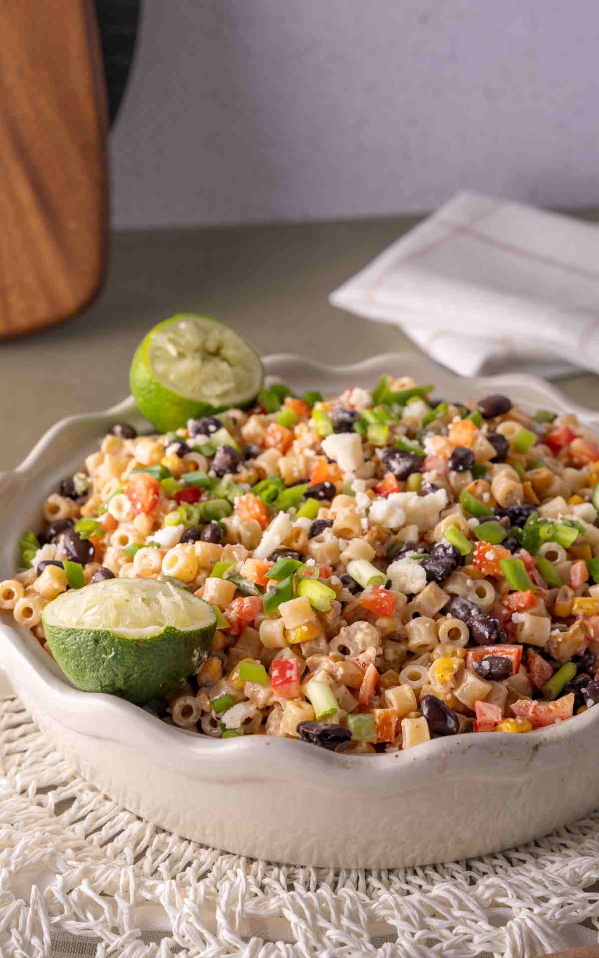 Cojita cheese sprinkled on a serving dish of Mexican street corn salad with ditalini pasta.