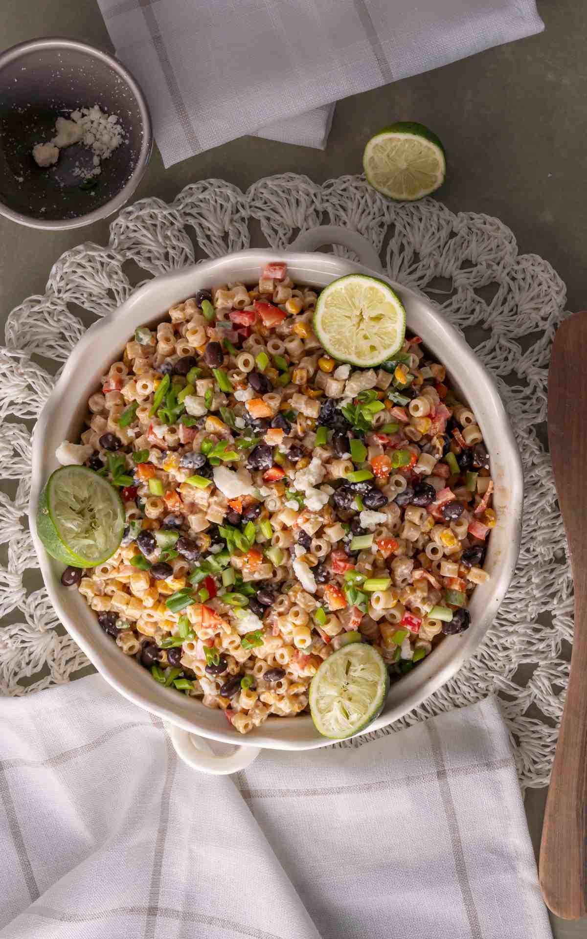 Mexican street corn pasta salad with cut and squeezed limes.