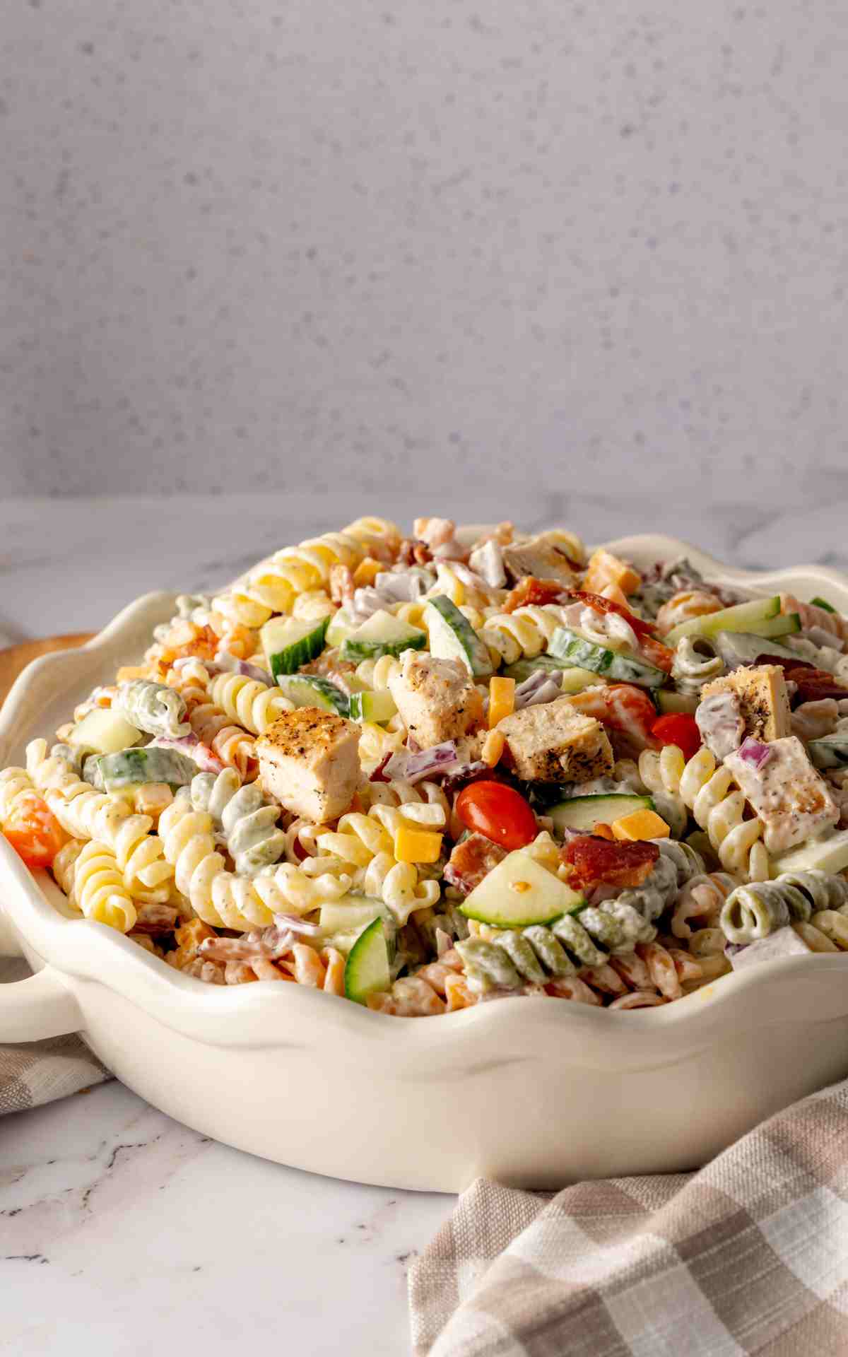Rotini pasta in a cold pasta salad with bacon and ranch.