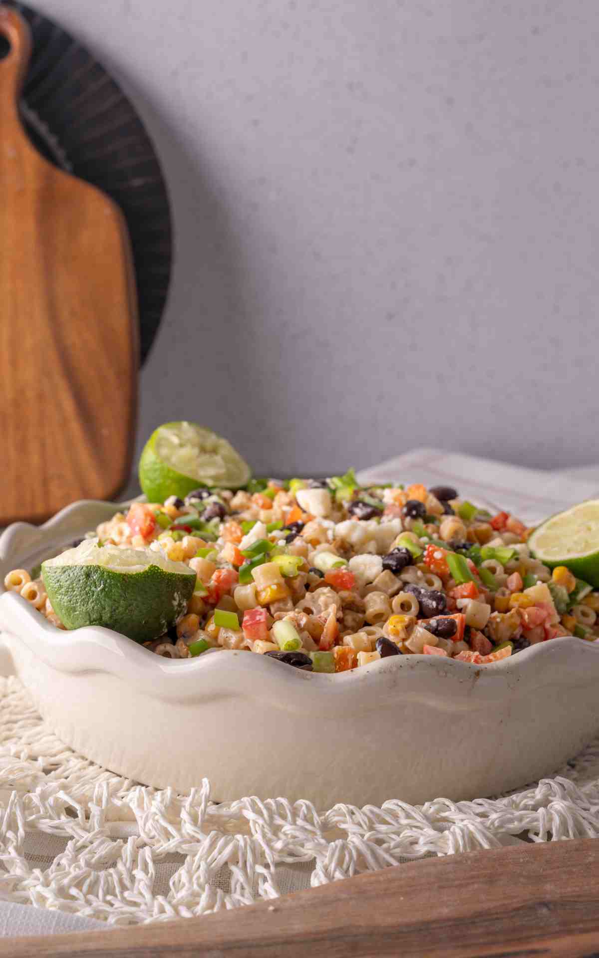 Scalloped bowl with pasta salad with grilled corn and limes.