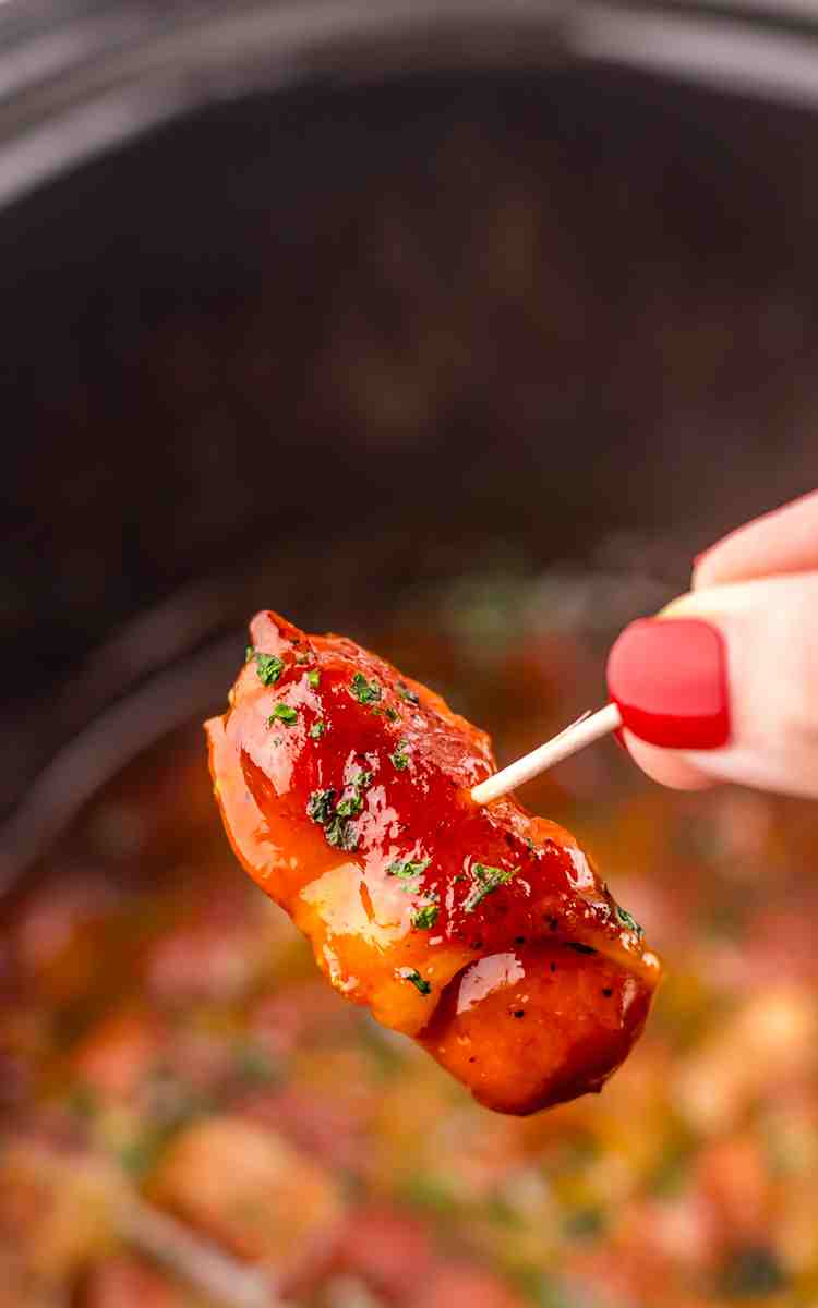 A toothpick in a bacon wrapped little smokie.