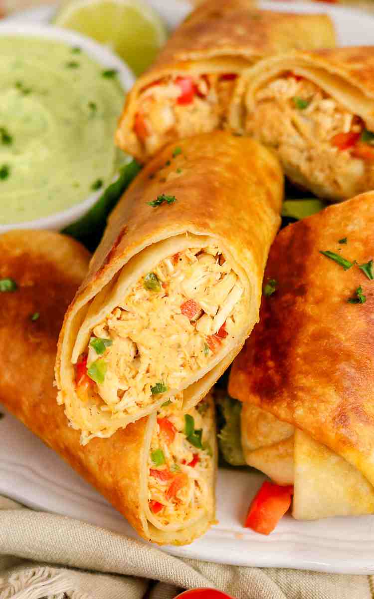 Close up of inside of a firecracker chicken wrap with avocado lime dip.