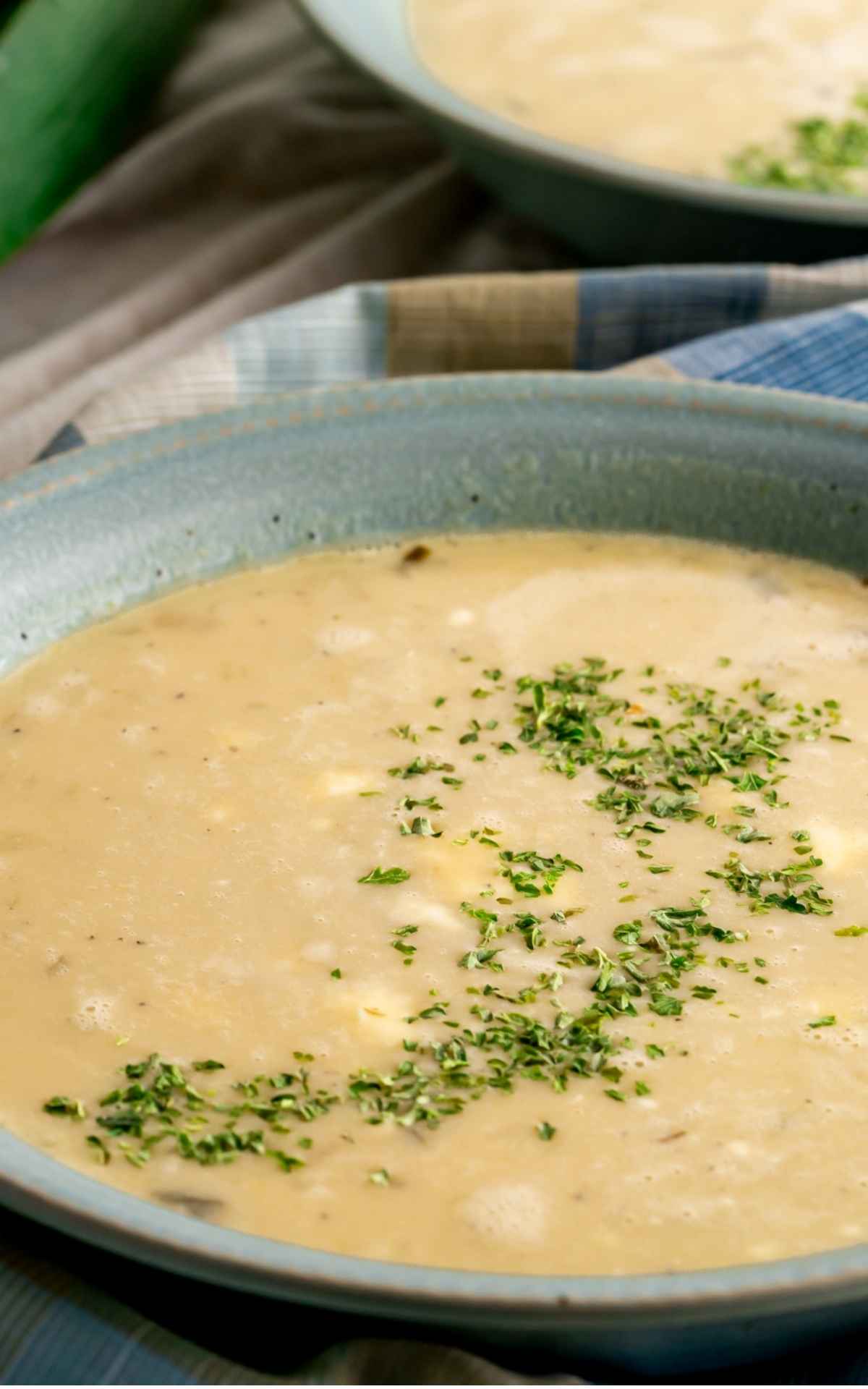 Close up of potato leek soup with sour cream and parsley.