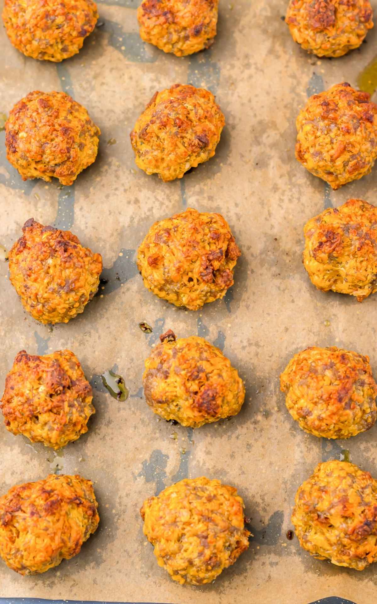 Baked Sausage balls cooling on parchment paper.